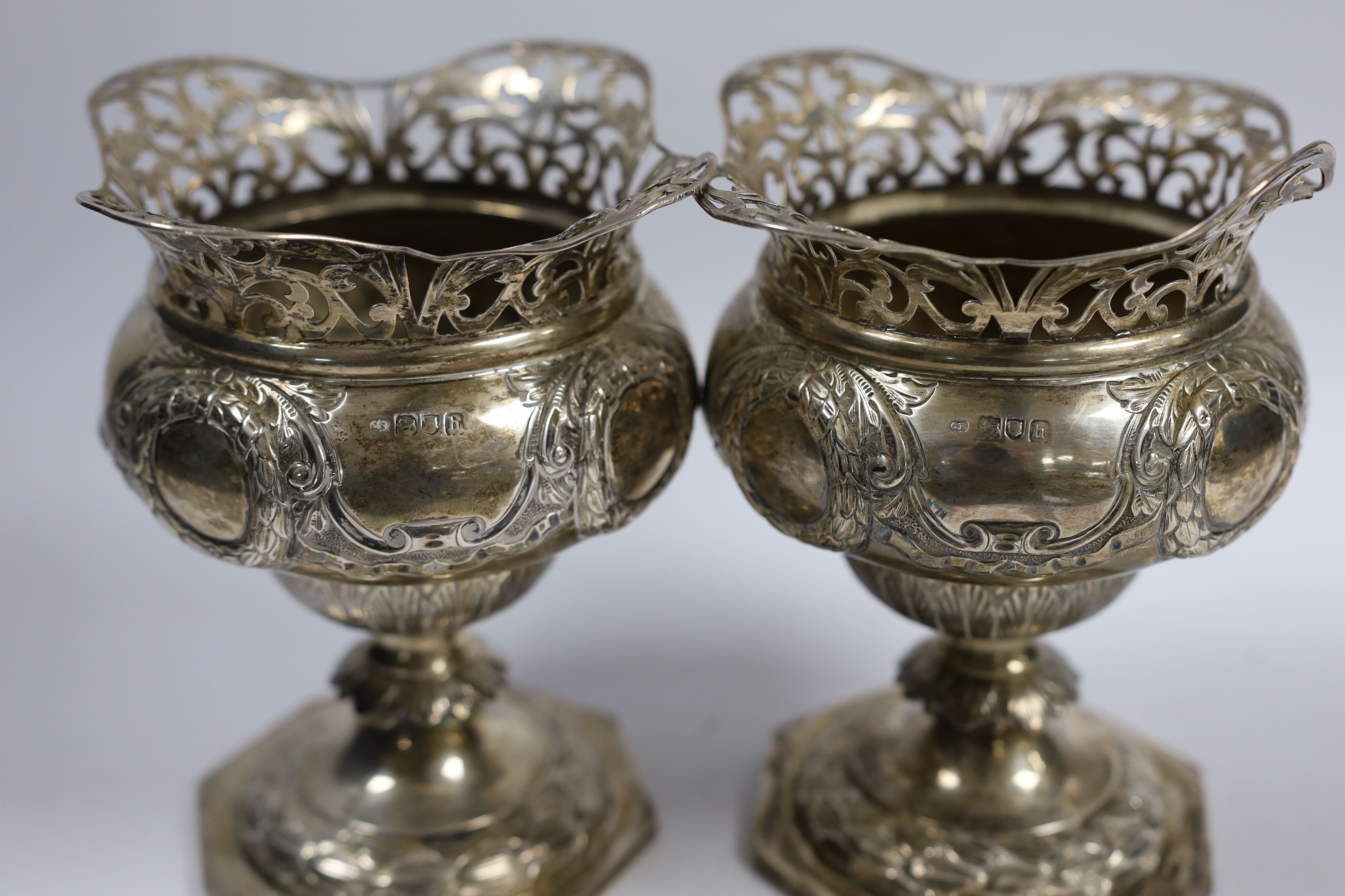 A pair of Edwardian silver pedestal vases, with pierced borders, Charles Edwards, London, 1903 height 15.8cm, 19.8oz.